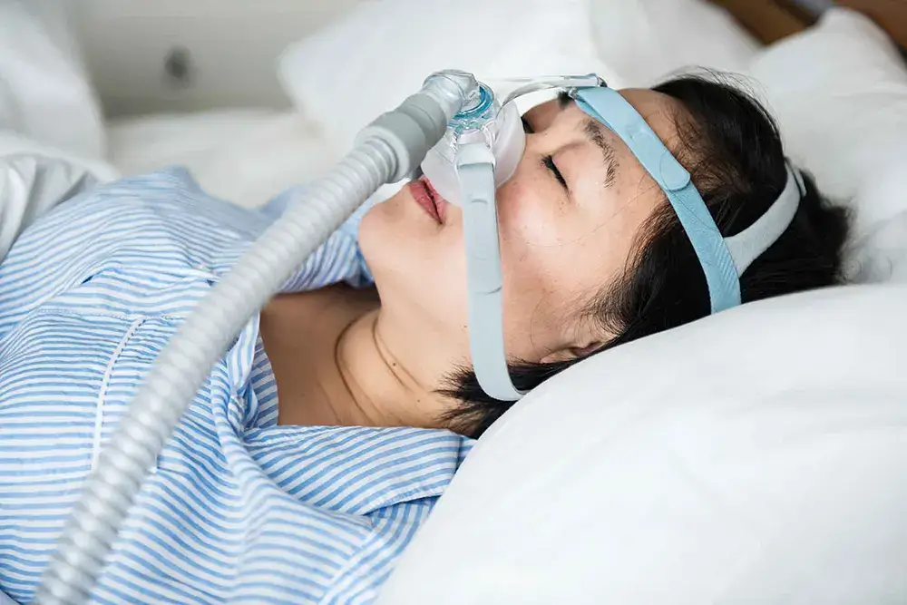Die CPAP-Therapie dieser Frau hilft ihr, nachts besser zu atmen.